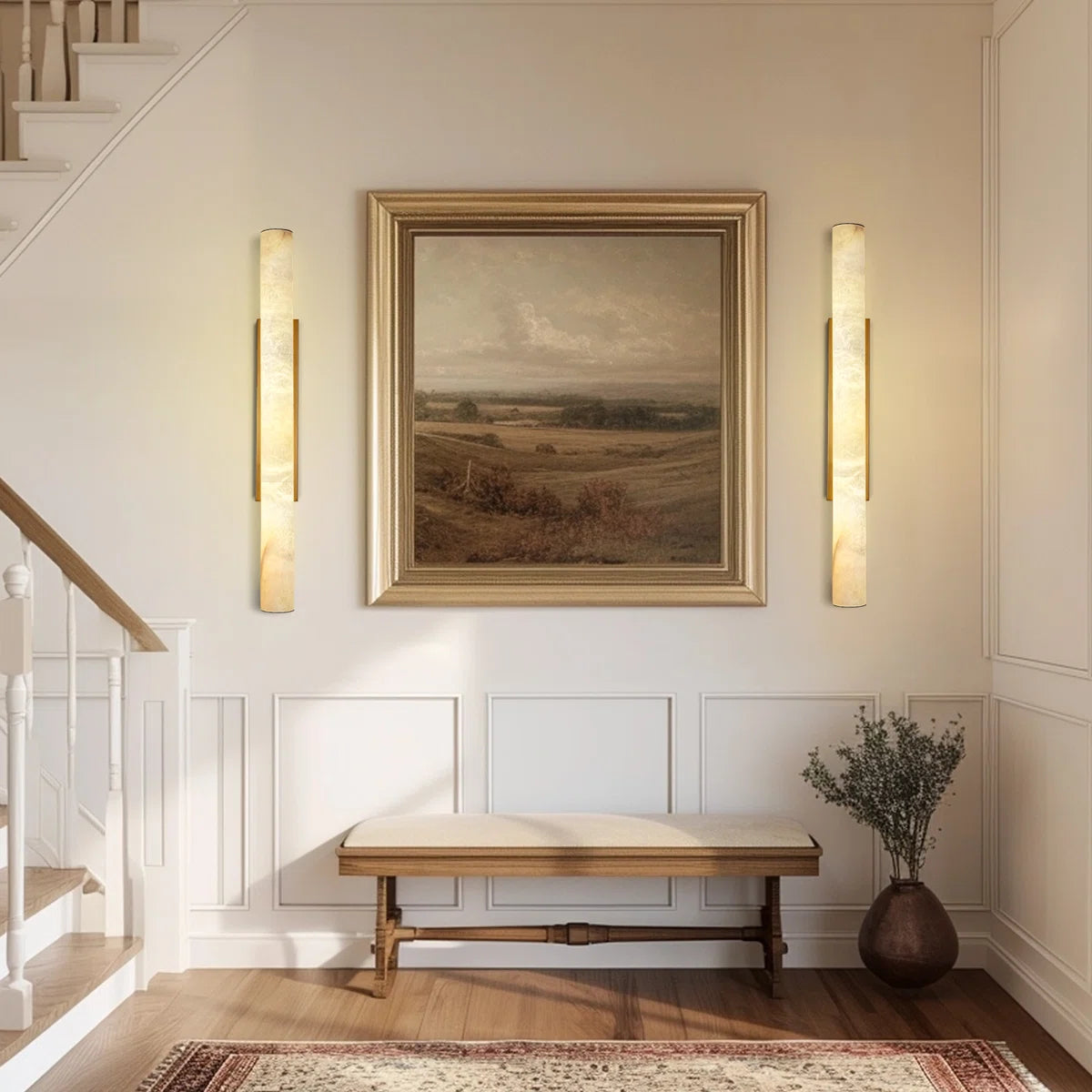 Staircase with wall sconces, a bench, and a framed painting in a home interior.