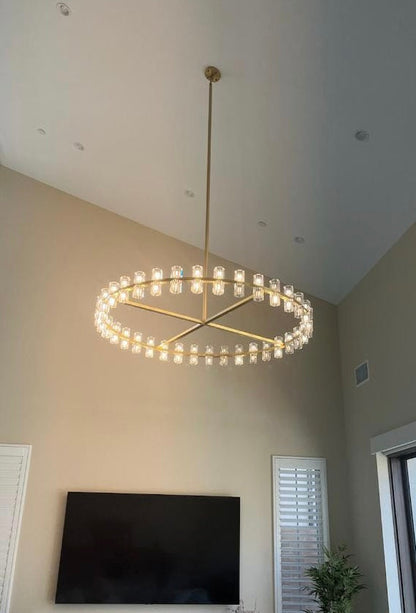 The rhythmic design of this chandelier collection is inspired by the shape and scale of industrial gears, where spokes are interlaced with negative space to interlock with other gears. Here, the spokes are hexagonal in form, juxtaposed with a circular interior, crafted from crystal glass, running along a simple, sturdy metal frame. The light shines through the glass as if it were a candle.